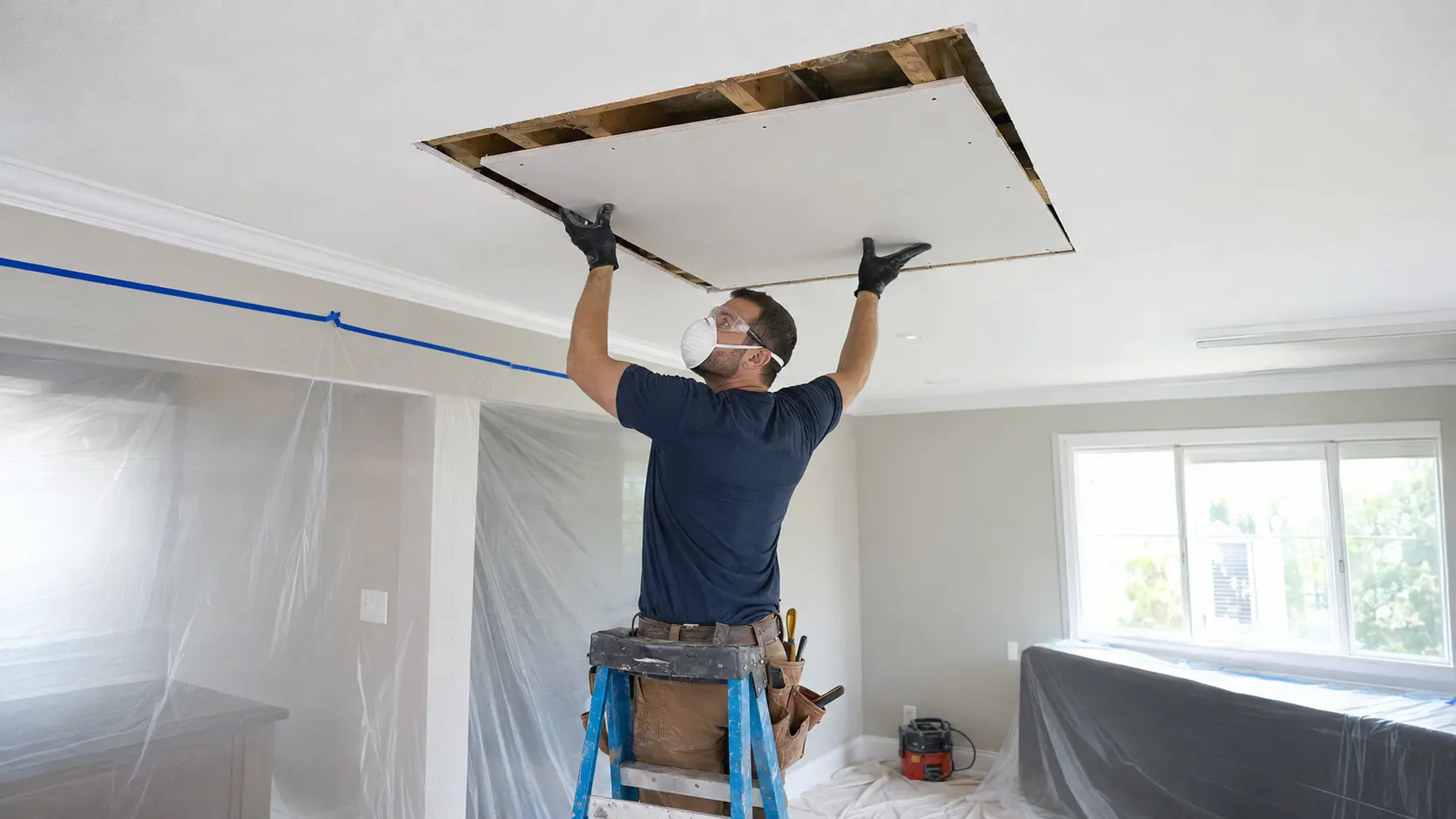 Professional replacing water-damaged drywall